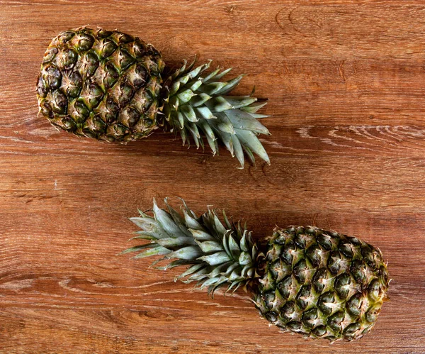 Ahşap arka plan hala hayat iki ananas — Stok fotoğraf