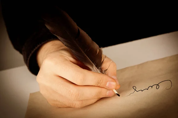 writer holds a fountain pen over writing paper and a signature