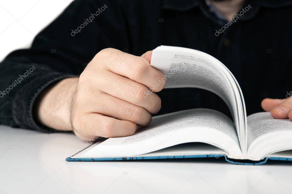 hands of a man thumbing a book closeup