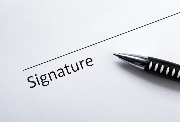 Un documento con lugar para una firma y un bolígrafo —  Fotos de Stock
