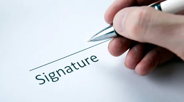 Um documento com um lugar para uma assinatura e uma mão de um homem wi — Fotografia de Stock