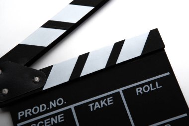 Beyaz bir masa üzerinde beyaz yazılar olan siyah film alkışlayıcısı.
