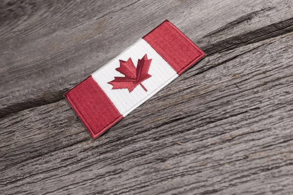 Embroidered Canadian Flag Patch Sits Grungy Wooden Plank — Stock Photo, Image