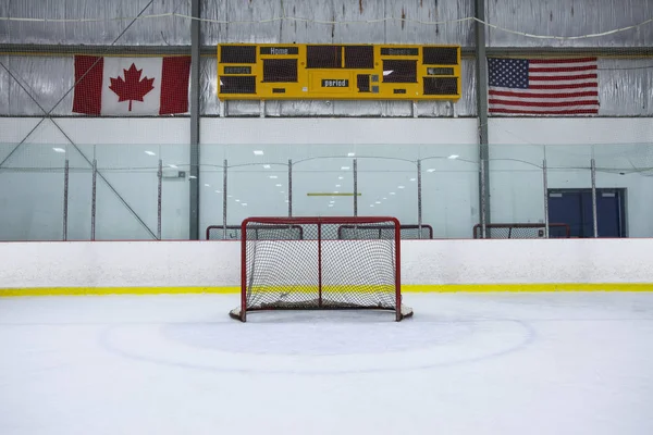 Bir hokey net geniş açı bakış bir eğlence hokey pisti üzerinde. Boş bir çetele, Kanada ve Amerikan bayrakları ek yükü duvara asmak..