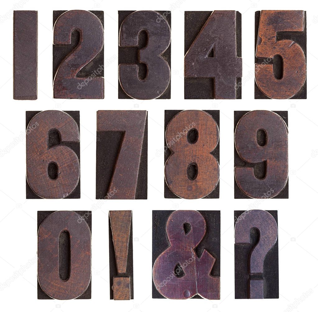 A set of antique wooden letterpress numbers and punctuation isolated on a white background. 