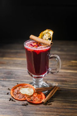 Tahta bir masada tarçınlı ve portakallı sıcak baharatlı şarap..