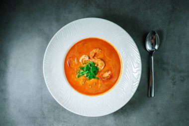 Taş bir tezgahın üstünde taze pişmiş sıcak çorba. Tom Yum karides ve yeşilliklerle dolu..
