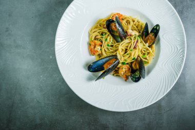 Taş tezgahın üstünde karides ve midyeli lezzetli bir makarna..