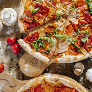 Taze sebzeli, jambonlu ve pepperonili ev yapımı leziz peynirli pizza..