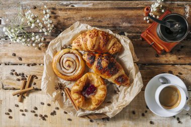 Tabakta taze pişmiş, çıtır çıtır fırın. Yakın plan. Kahve fincanı parçaları ve kahve makinesinin yanında..