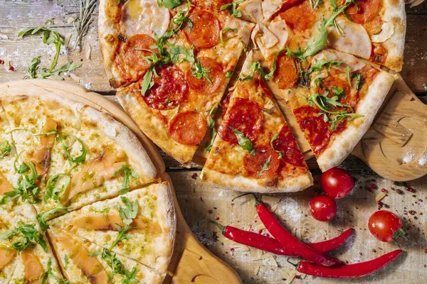 Taze sebzeli, biberli ve ahşap masada jambonlu nefis ev yapımı peynirli pizza..