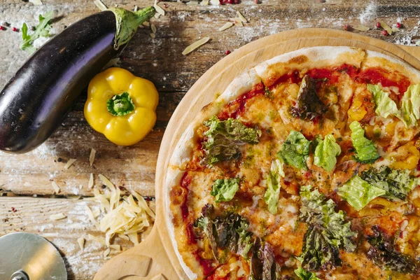 Lezzetli, peynirli, ev yapımı, taze sebzeli, ahşap bir masada pizza..