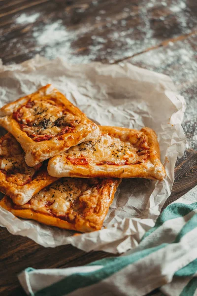Peynirli, domatesli, mozarellalı ve ahşap kaplamalı nefis ev yapımı pizza. Kapat..