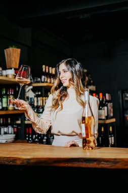 Tecrübeli zarif şarap garsonu kadın restoranda kırmızı şarap tadıyor. Tadı, rengi, şarap tortularını kontrol ediyorum. Metin için boşluk.