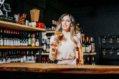 Tecrübeli zarif şarap garsonu kadın restoranda kırmızı şarap tadıyor. Tadı, rengi, şarap tortularını kontrol ediyorum. Metin için boşluk.