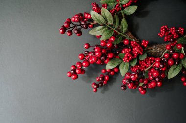 Gri arka planda kırmızı Noel çelengi. Metin için boşluk.