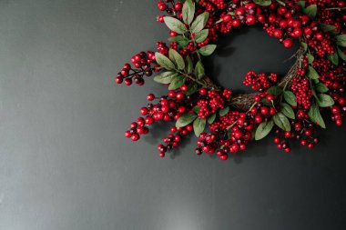 Gri arka planda kırmızı Noel çelengi. Metin için boşluk.