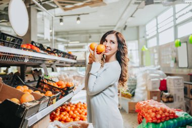 Markette meyve seçen genç ve güzel bir kadın. Sağlıklı yaşam tarzı kavramı.