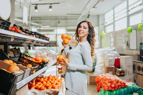 Markette meyve seçen genç ve güzel bir kadın. Sağlıklı yaşam tarzı kavramı.
