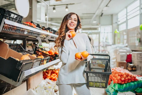 Markette meyve seçen genç ve güzel bir kadın. Sağlıklı yaşam tarzı kavramı.