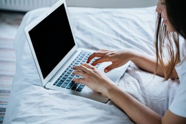 Yatağında dizüstü bilgisayar kullanan bir kadın. Tasarım şablonu