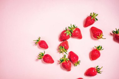 Açık pembe arka planda taze çilek. Yukarıdan bak. Metin için yer.