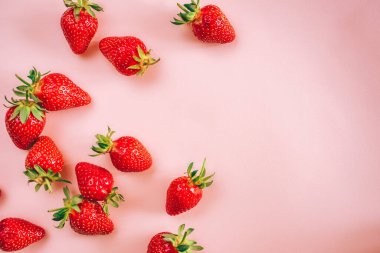 Açık pembe arka planda taze çilek. Yukarıdan bak. Metin için yer.