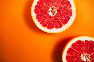 Turuncu arka planda taze kesilmiş greyfurt. Yukarıdan bak. Metin için yer.