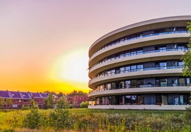 Hollanda 'nın apeldoorn şehrinde günbatımında modern apartmanlar inşa ediliyor.