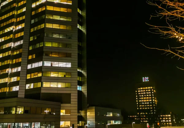 Verlichte wolkenkrabber met andere verlichte gebouwen 's nachts, moderne Nederlandse stadsarchitectuur, Utrecht, 23 januari 2020 — Stockfoto