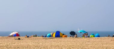 Çadırları ve şemsiyeleriyle yıkanan turistler Domburg, Zeeland, Hollanda, 26 Ağustos, 2019