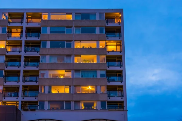 Apartments complex with lighted windows in the evening, modern city architecture in tilburg, The Netherlands — ストック写真