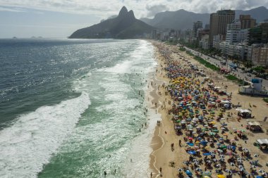 Ipanema 'da kalabalık bir plajın ve Rio de Janeiro' da Leblon 'un havadan panoramik görüntüsü.