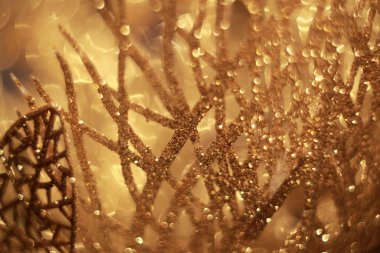 Abstract close-up of christmas decorations: shiny golden leaves with glitter. 