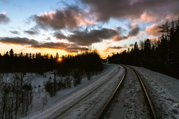 Lebendiger Sonnenuntergang über winterlichen Bahngleisen — Stockfoto