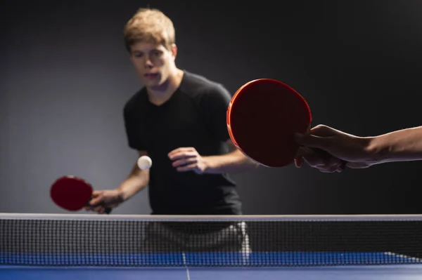 Pás de ping pong de tênis de mesa e bola branca no tabuleiro azul — Fotografia de Stock