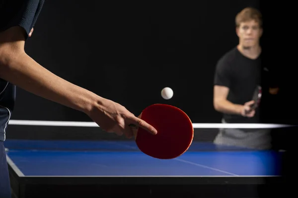 Pás de ping pong de tênis de mesa e bola branca no tabuleiro azul — Fotografia de Stock