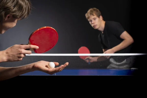 Table tennis ping pong paddles and white ball on blue board — Stock Photo, Image