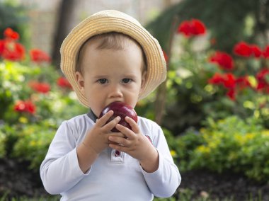 Güzel baharda bahçede çimlerin üzerinde oturan bebek.