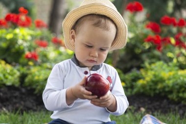 Güzel baharda bahçede çimlerin üzerinde oturan bebek.