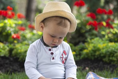 Güzel baharda bahçede çimlerin üzerinde oturan bebek.