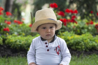 Güzel baharda bahçede çimlerin üzerinde oturan bebek.