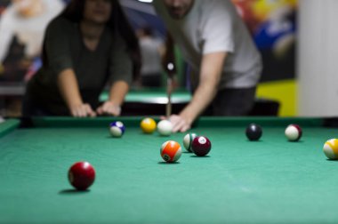 Genç arkadaşlar barda bilardo oynuyorlar.