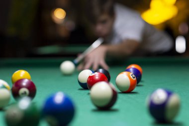 Barda bilardo oynayan genç adam. 
