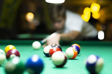 Barda bilardo oynayan genç adam. 