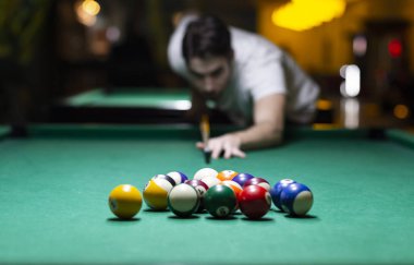 Barda bilardo oynayan genç adam. 