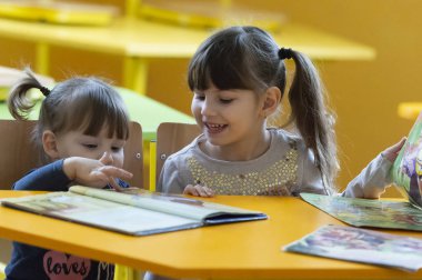 Küçük kızlar okulda eğleniyor. 