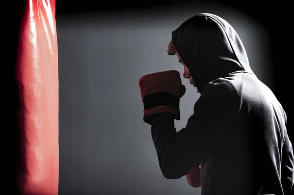 Le jeune homme s'entraîne un coup de pied sur le sac de boxe — Photo