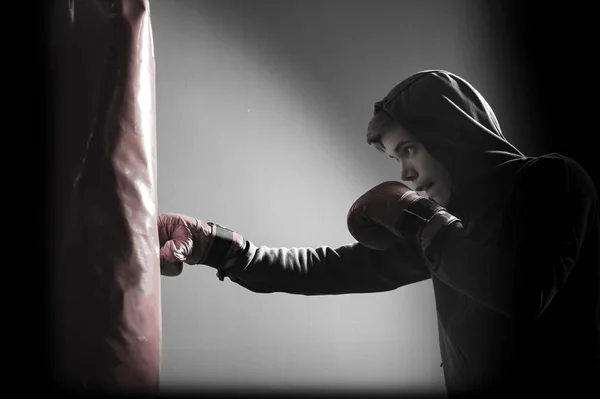 Il giovane allenamento un calcio sul sacco da boxe — Foto Stock