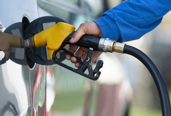 Man filling gasoline fuel in car holding nozzle